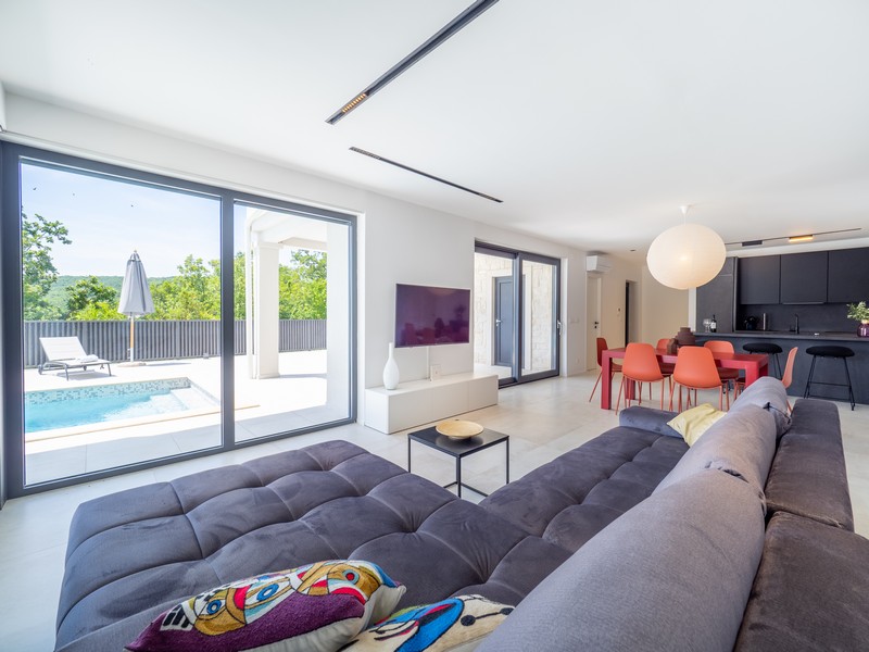 Vardagsrum med utsikt över terrass och pool