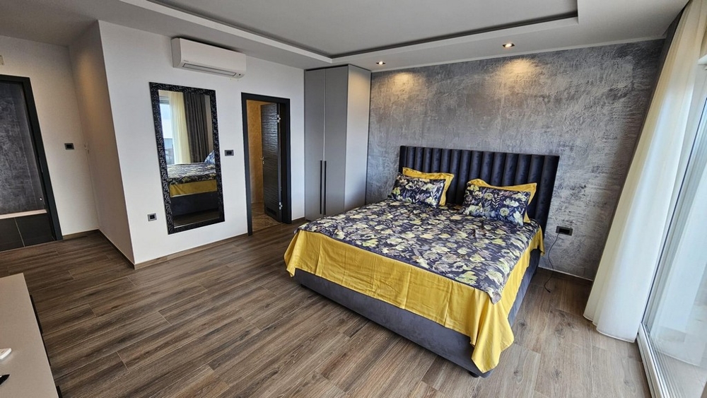 Sovrum med dubbelsäng och subtil väggdesign