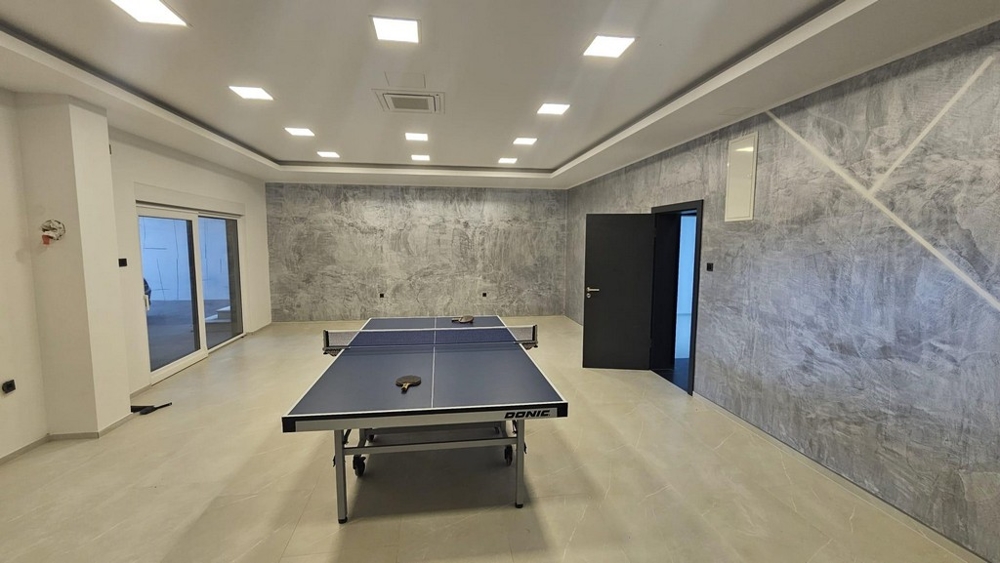 Rymligt fritids- eller gymrum med bordtennisbord