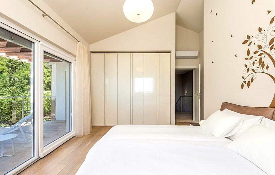 Ljust sovrum med balkong och modern inredning
