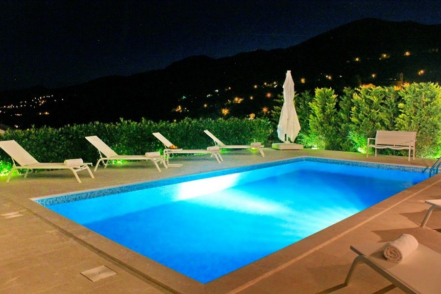 Pool på natten med belysning och utsikt