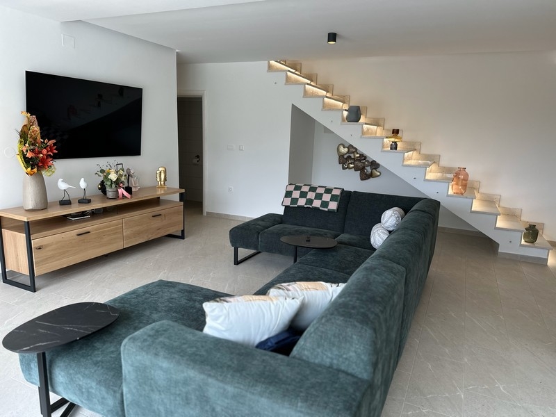 Vardagsrum med elegant trappa och dekoration