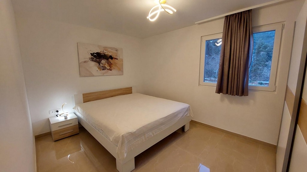 Sovrum med dubbelsäng och neutral inredning