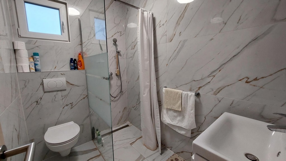 Badrum med dusch och marmordetaljer av fastighet H3491 i Kroatien