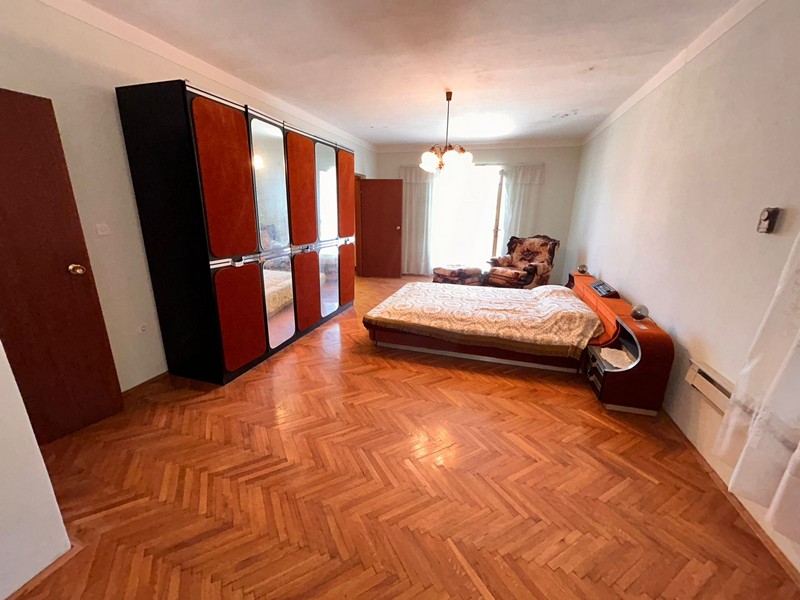 Stort sovrum med parkettgolv och utgång till altan