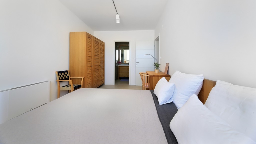 Utsikt från poolhäcken och loungen med ingången till villan.