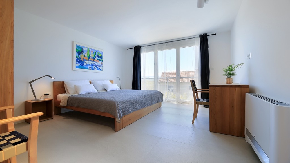 Utsikt över vardagsrummet med möbler av hög kvalitet och utgång till terrassen med pool.