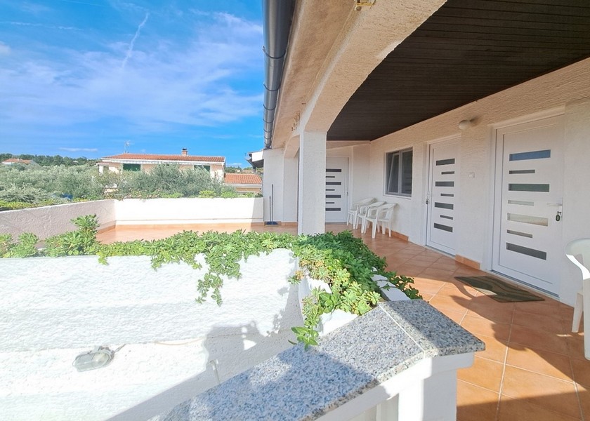 Balkongområde med växter och två studiodörrar.