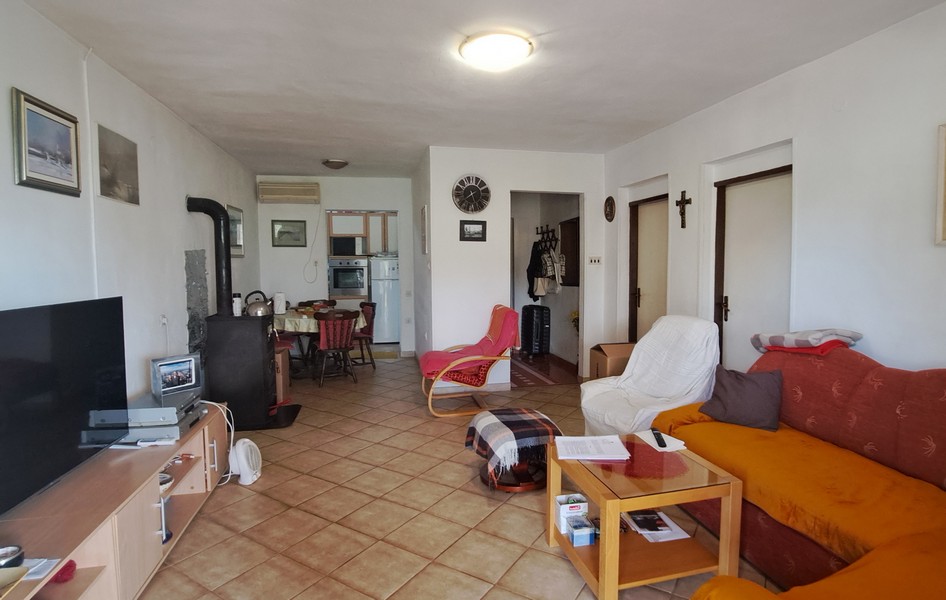 Vardagsrum med matplats och kök i bakgrunden.