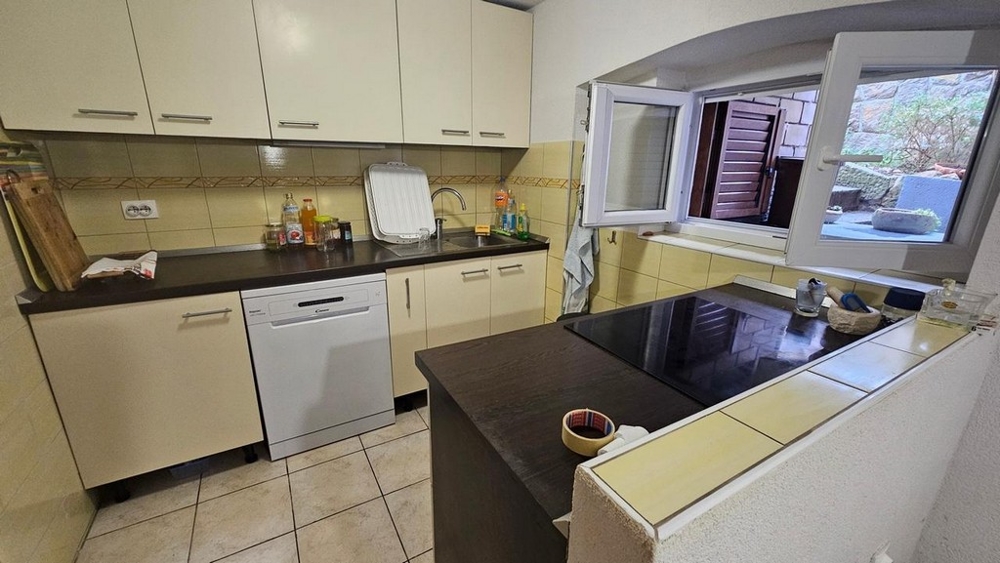 Modernt kök med vita fronter och fönster