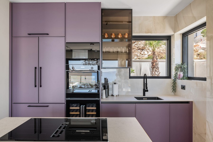 Modernt kök med lila inredning.