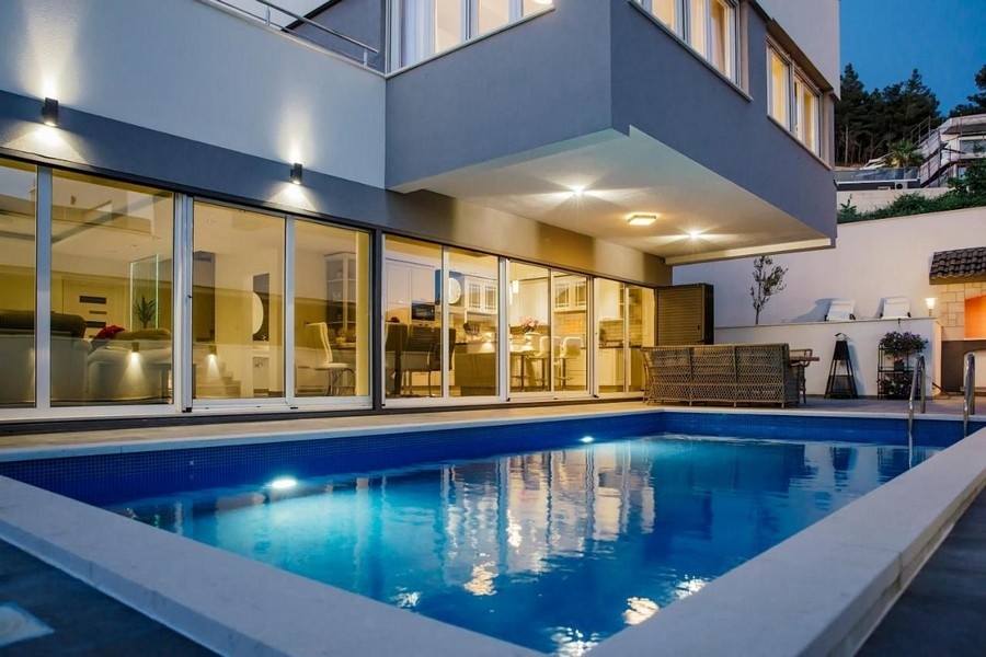 Exteriör vy av villa med pool i skymningen