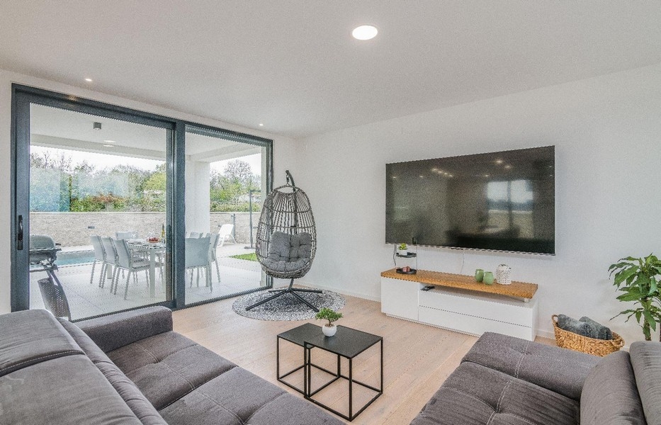 Modernt vardagsrum med stor glasfront och TV