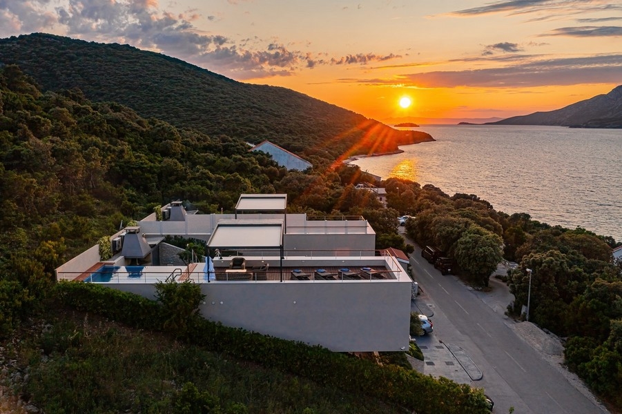 Villa i solnedgången med havet och naturen i bakgrunden