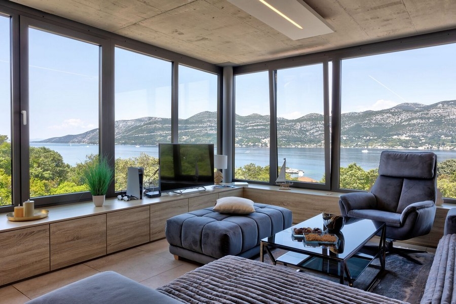 Stilrent inrett vardagsrum med panoramafönster