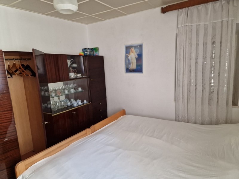 Sovrum med dubbelsäng, väggskåp och väggmålning