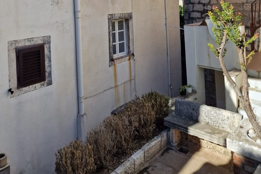 Innergård med stenmurar och liten bänk