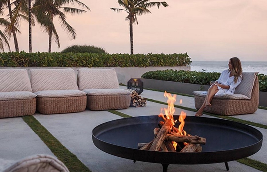 Loungeområde med eldstad, havsutsikt och palmer