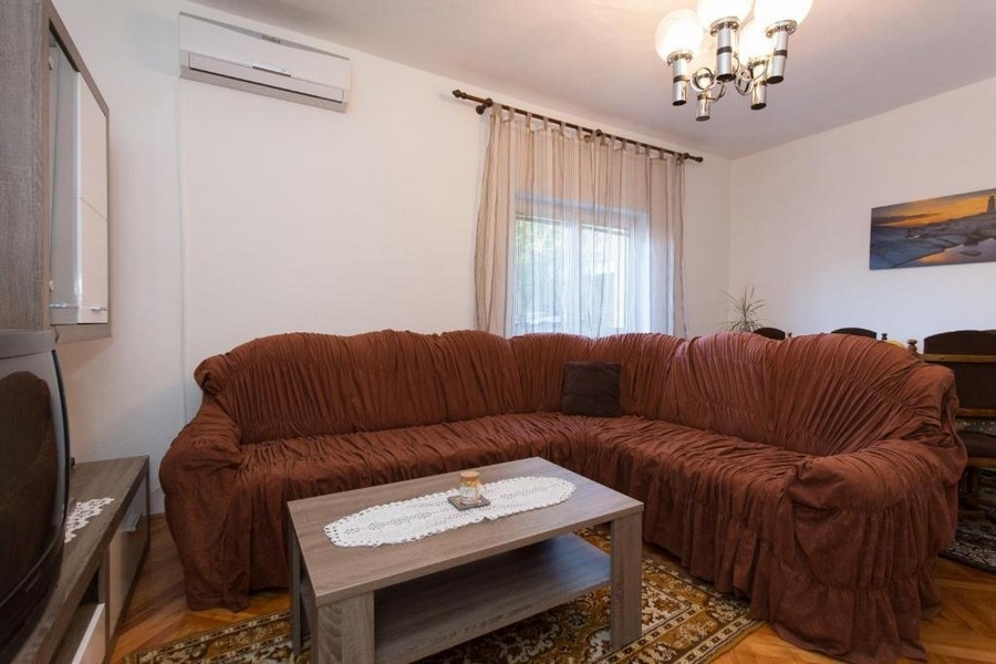 Vardagsrum med stor soffgrupp och luftkonditionering