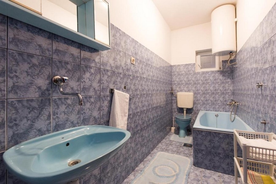 Badrum med blått kakel, badkar och handfat