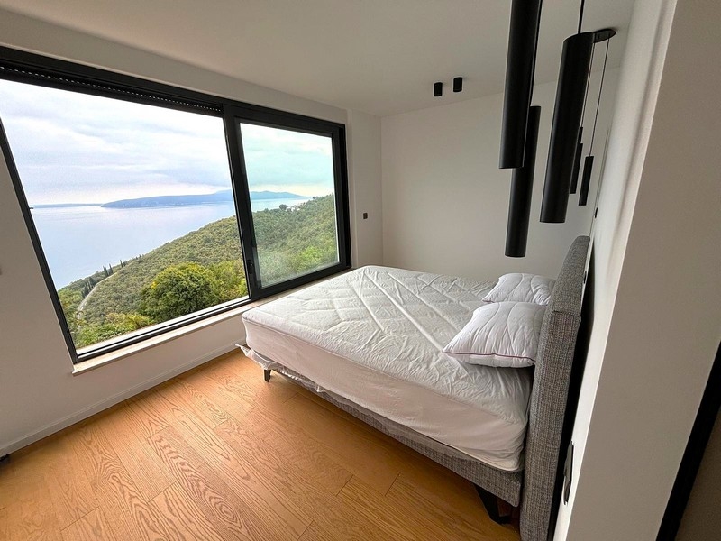 Ljust sovrum med stort fönster och havsutsikt