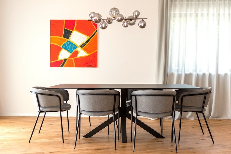 Matplats med designlampa och stora konstverk på väggen