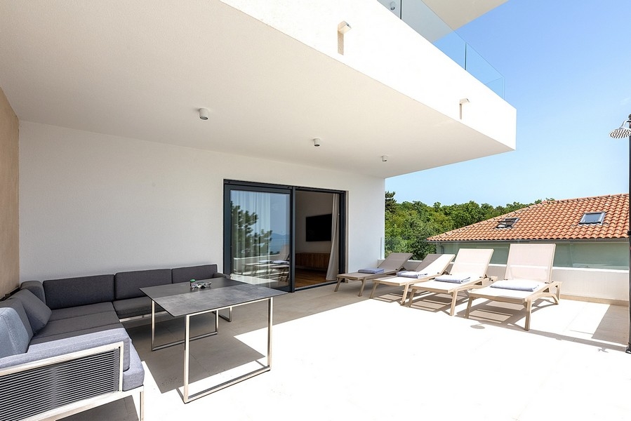 Täckt terrass med loungemöbler och solstolar