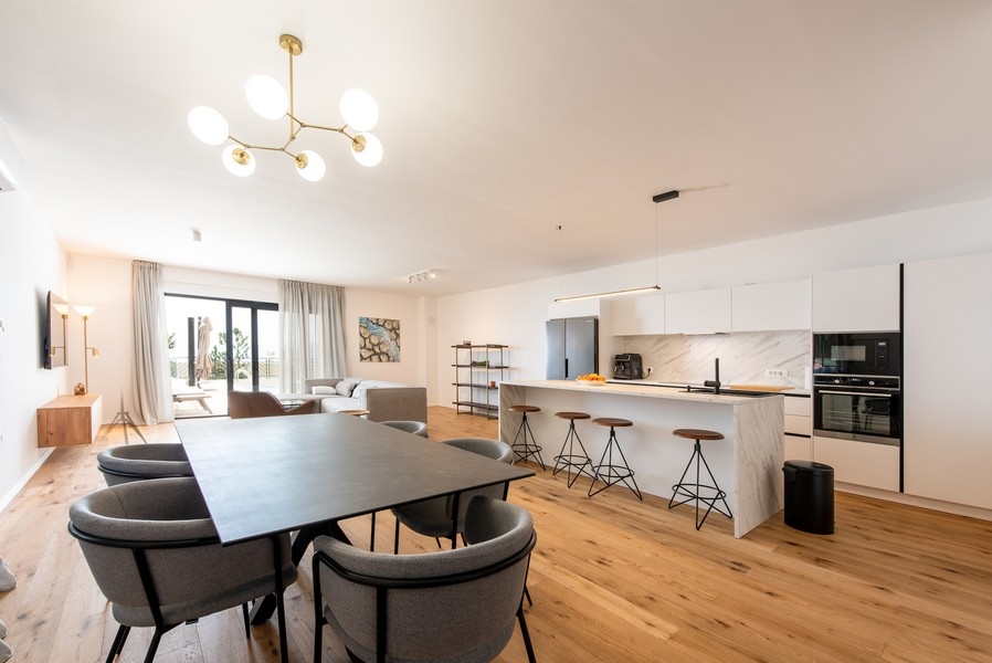 Öppen vardagsrumsdel med kök, matplats och modern inredning