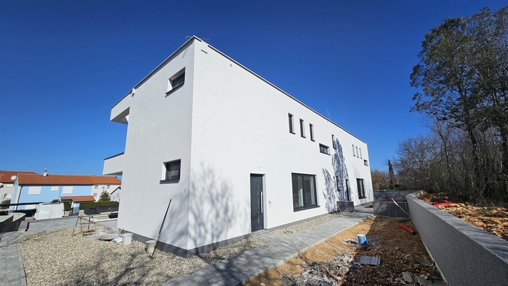 Exteriör vy av den nya byggnaden med trädgård