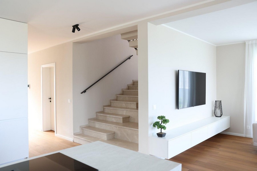 Modernt ljust kök med hängande hyllor och inbyggda vitvaror