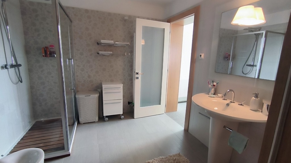 Modernt badrum med stor dusch och spegel