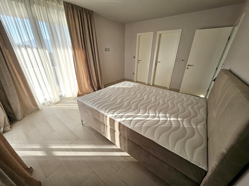 Rymligt sovrum med stora fönster och dubbelsäng