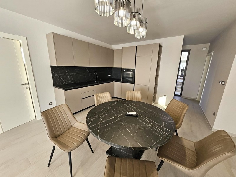 Modernt kök med svarta arbetsytor och runt matbord