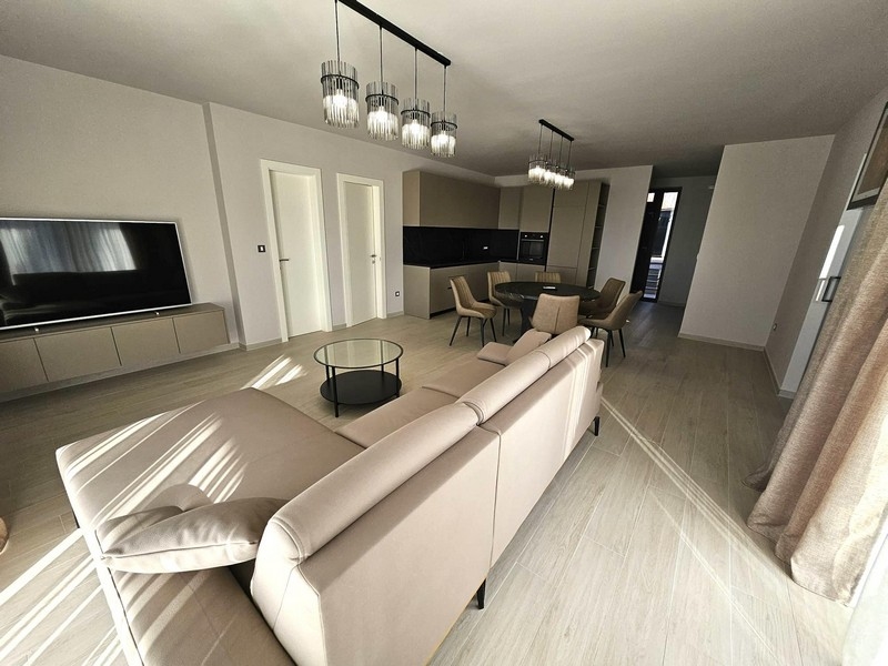 Öppen vardagsrumsdel med soffa, TV och designlampor