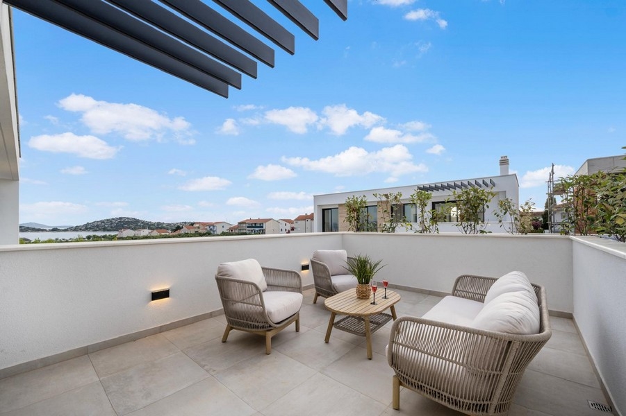 Modern terrass med sittplatser och havsutsikt i Tribunj