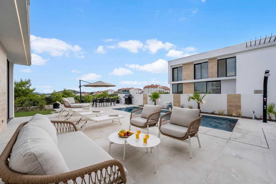 Uteplats med pool, solstolar och grillplats