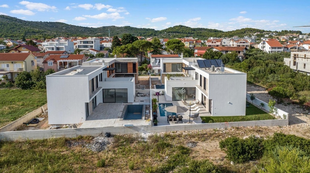 Nybyggd villa från luften med pool och trädgård