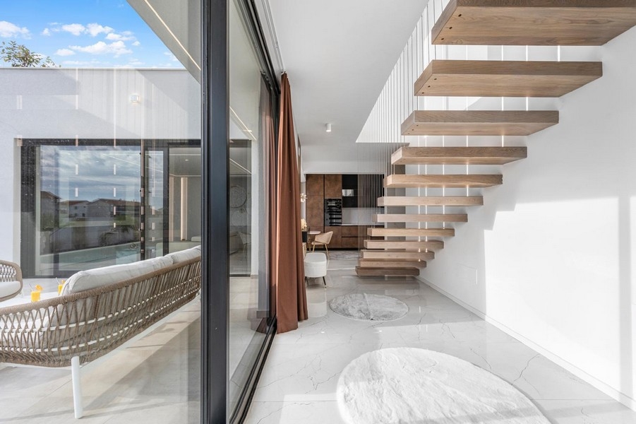 Ljust galleri med flytande trappa och stora fönster