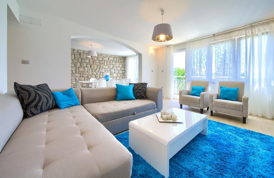 Modernt vardagsrum med stor soffa och havsutsikt