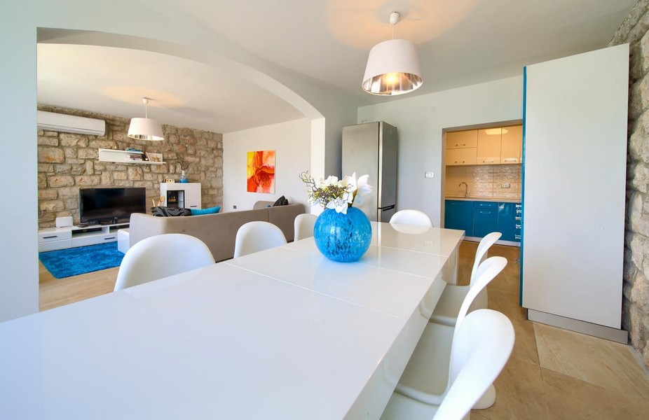 Öppet vardagsrum och matplats med naturstenvägg