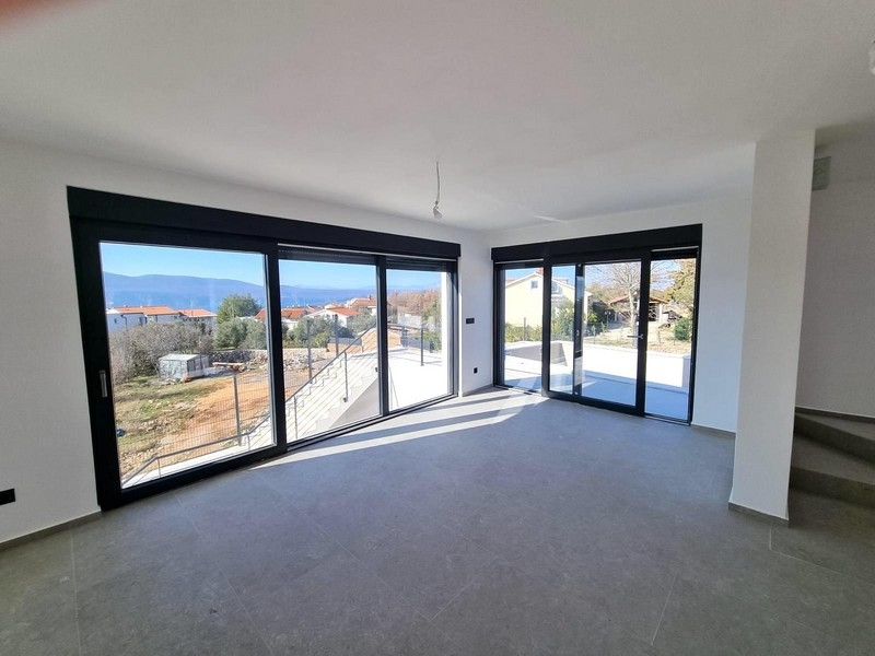 Vardagsrum med stora glasfronter och havsutsikt