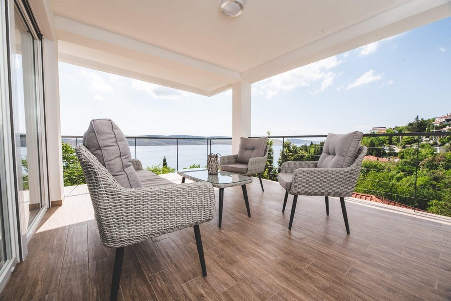 Täckt terrass med sittgrupp och havsutsikt