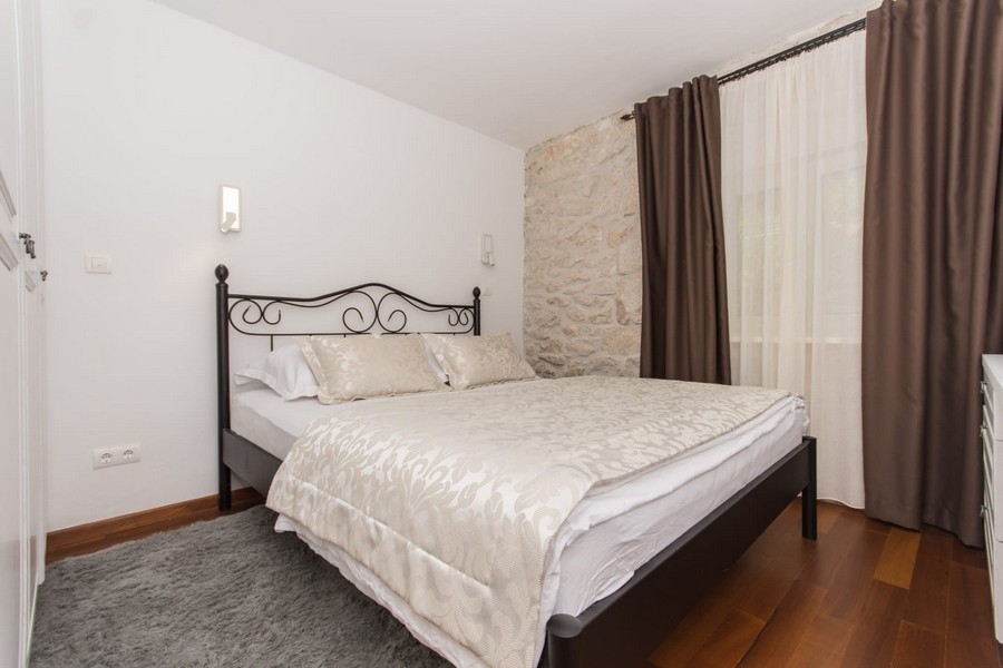 Sovrum med dubbelsäng och stenvägg