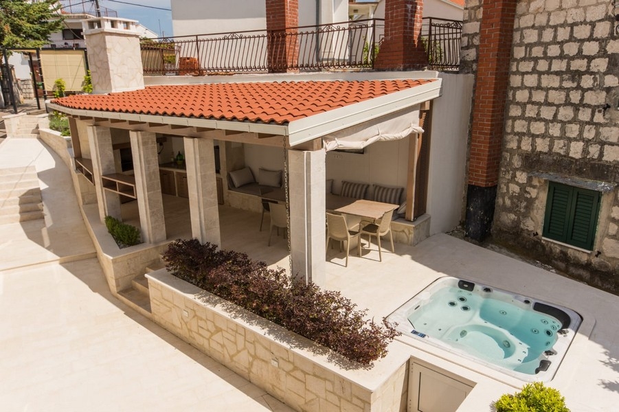 Terrass med badtunna och täckt sittgrupp