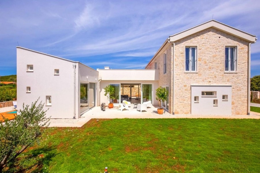 Modern villa med naturstensfasad och trädgård