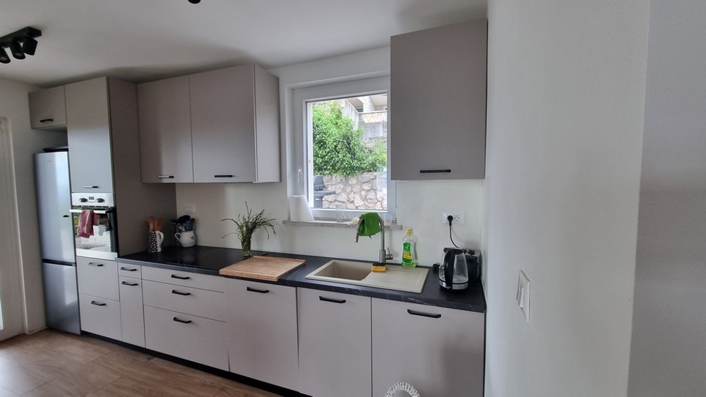 Modernt kök med fönster och utsikt över trädgården