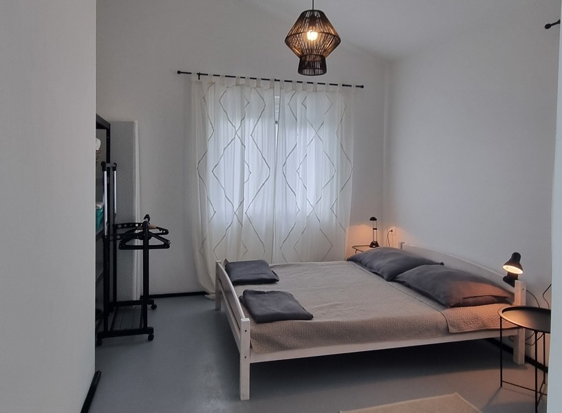 Sovrum med dubbelsäng och klädhängare