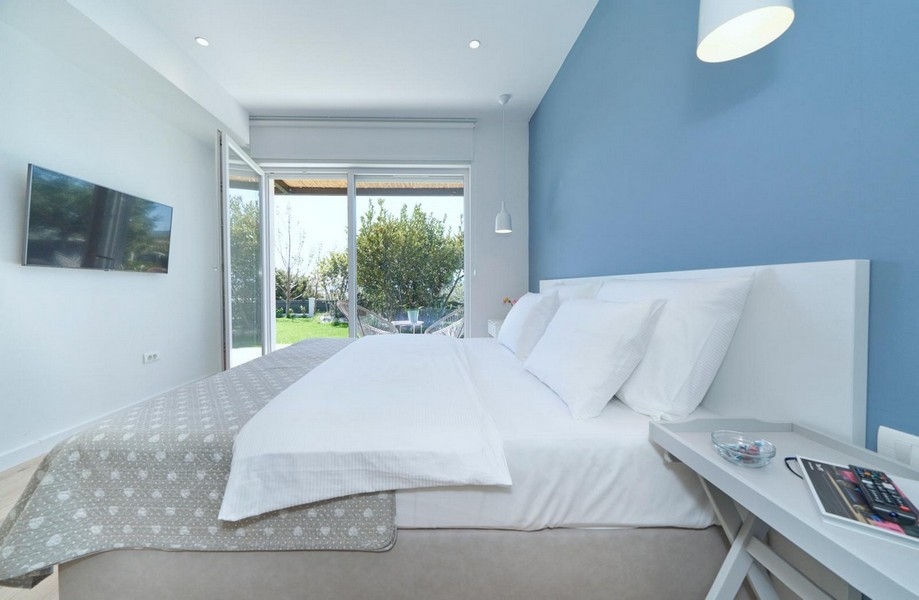 Sovrum med dubbelsäng och tillgång till trädgården
