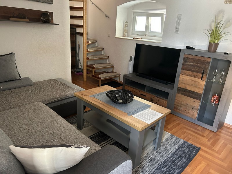 Vardagsrum med tv och trappor