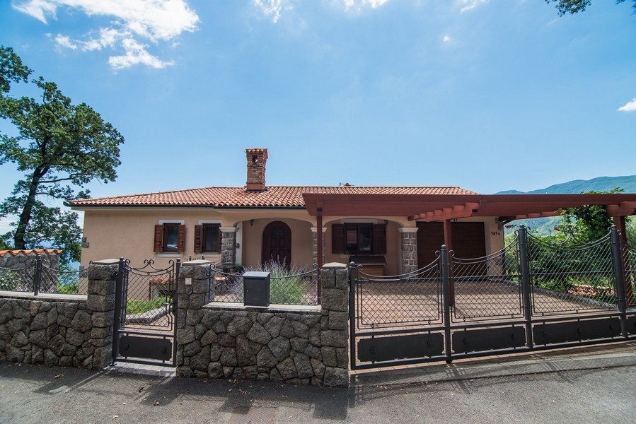 Framifrån av villan med ingång och grind